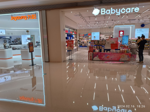 Ein Babyladen in einem Einkaufszentrum mit Menschen, Spielzeugen, Regalen, Schildern, einem Anzeigebildschirm und Deckenleuchten, gelegen im Mall of Asia.