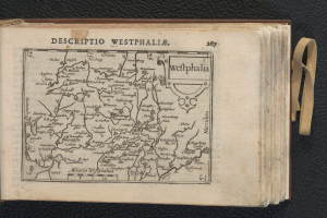 Ein aufgeschlagenes Buch mit einer detaillierten Landkarte von Westfalen, das auf einer schwarzen Oberfläche liegt.