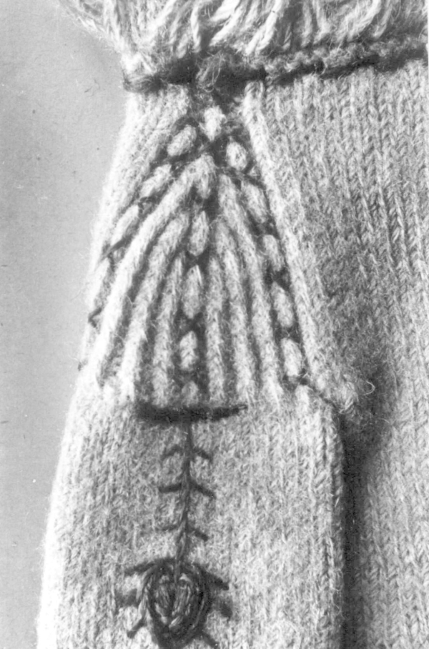 Ein Schwarz-Weiß-Foto eines Wollpullovers mit einem detaillierten Muster in verschiedenen Formen und Farben.