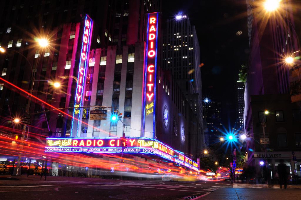 Gebäude und Straßenlaternen säumen eine Straße mit einigen Fußgängern.