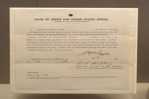 Ein Blatt Papier mit dem Text "Dienstaufsichtsbeschwerde" darauf, das auf einem Tisch vor einer Wand liegt.