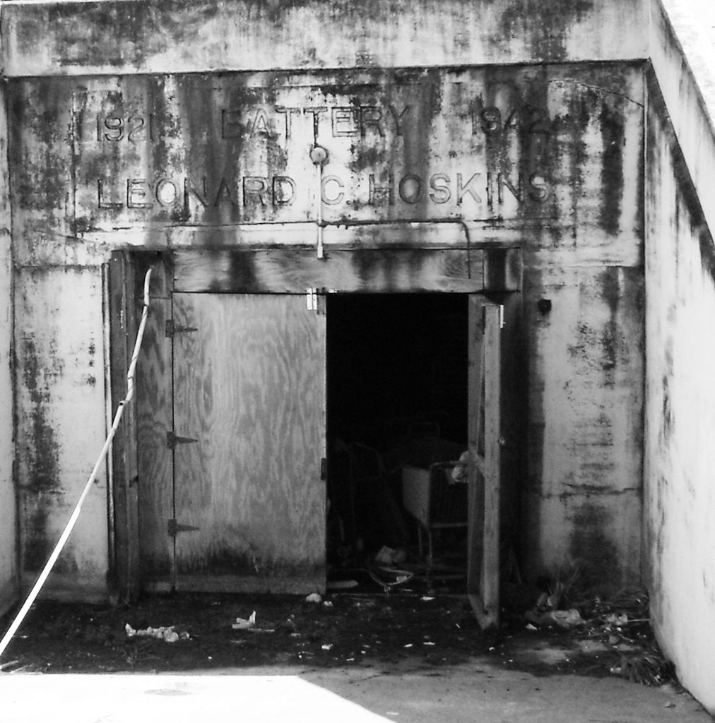 Zwei geschlossene Holztüren in einem Schwarz-Weiß-Bild, das offenbar ein Geschäft zeigt.