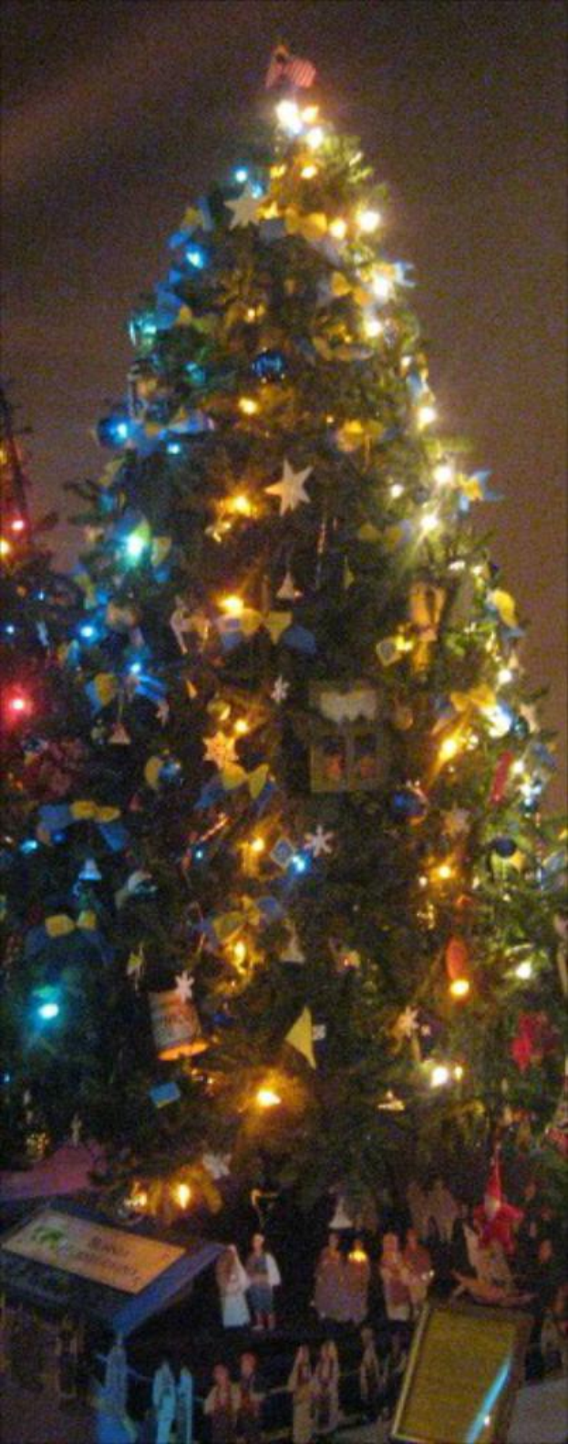 Ein geschmückter Weihnachtsbaum mit Figuren von Menschen darauf.