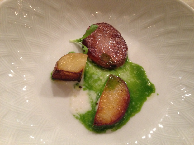 Eine Schüssel mit Fleischstücken und Chili-Sauce auf einem Tisch.