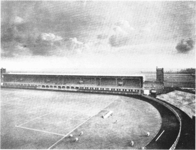 Schwarzes und weißes Foto eines Fußballfeldes mit einem Stadion im Hintergrund, umgeben von Bäumen und einer bewölkten Himmel, mit dem Text "Stoke City Football Club" unten.