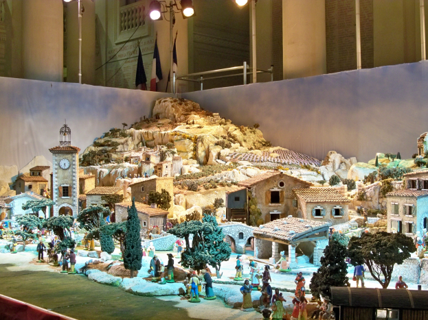 Ein detailgetreues Miniatur-Modell einer Krippe im Museum, mit Figuren, Strukturen und beleuchteten Elementen, die eine festliche Stimmung schaffen.