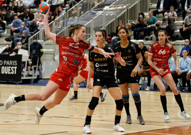Eine Gruppe von Frauen beim Handballspielen auf einem Platz während der Handball-Weltmeisterschaft 2019 in Paris mit Zuschauern im Hintergrund.