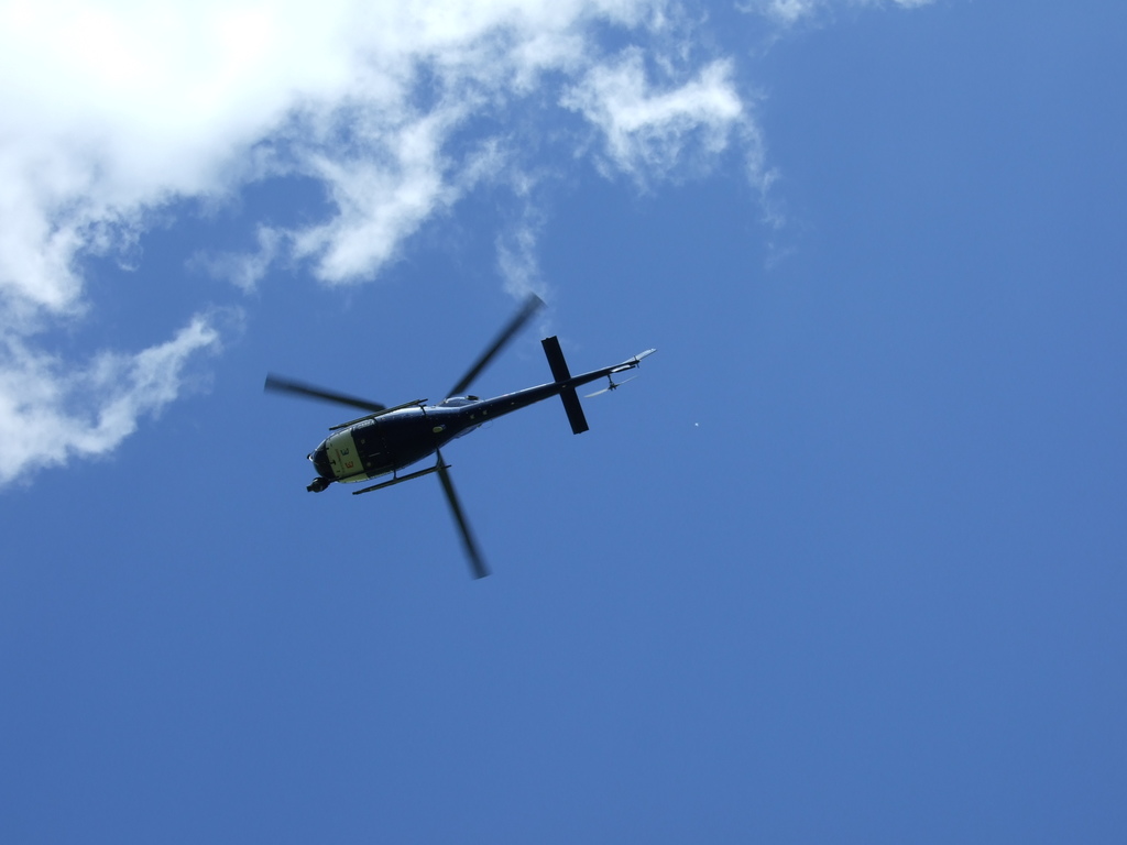 Ein Hubschrauber fliegt in einem blauen Himmel.