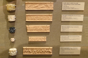 Eine Vitrine voller verschiedener altertümlicher Artefakte, darunter Schnitzereien und Texte auf Tafeln, ordentlich und sauber angeordnet.