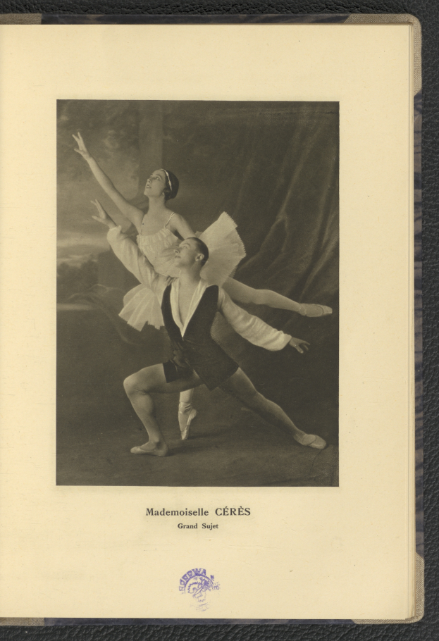 Ein Schwarz-Weiß-Foto eines Mannes und einer Frau in Ballettkleidung, die perfekt synchron tanzen, wobei der Mann ein weißes Tutu trägt und die Frau ein rosafarbenes Kleid trägt, Text unten im Rahmen.