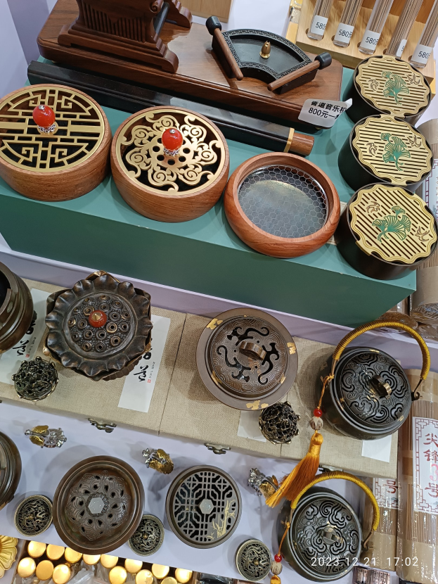 Ein Tisch mit verschiedenen chinesischen Räucherstäbeln, Boxen, Papieren mit Text und anderen Gegenständen, die likely für ein chinesisches Neujahrsfest arrangiert sind.