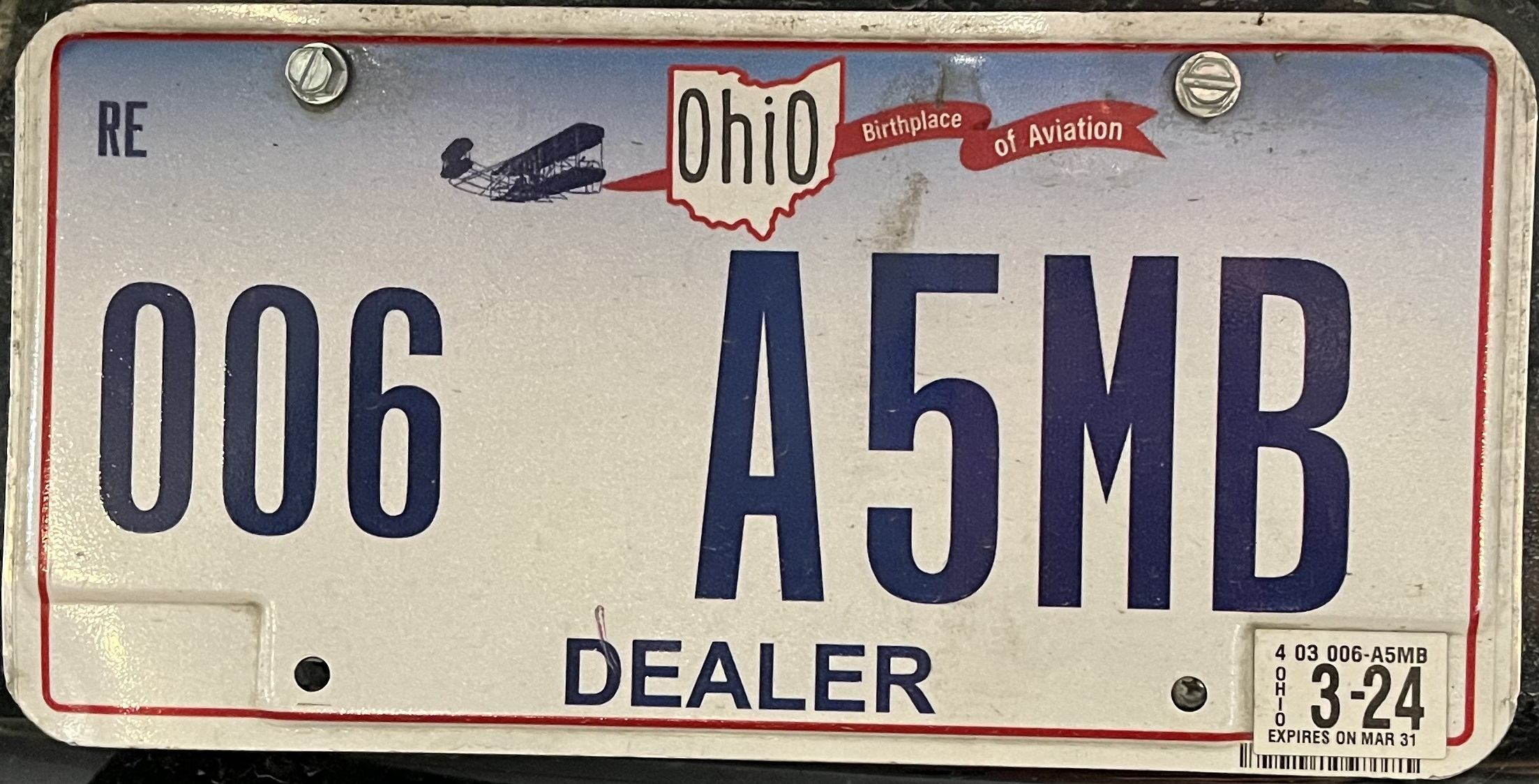 Ein Kennzeichen an der Rückseite eines Autos mit Text und Zahlen.