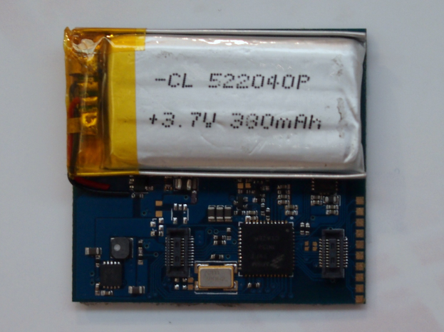 Nahaufnahme einer Handybatterie mit gedrucktem Text auf einer Leiterplatte und weißer Oberfläche.