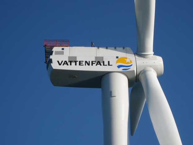Eine weiße Windkraftanlage mit der Aufschrift "Vattenfall" steht vor einem hellblauen Himmel.