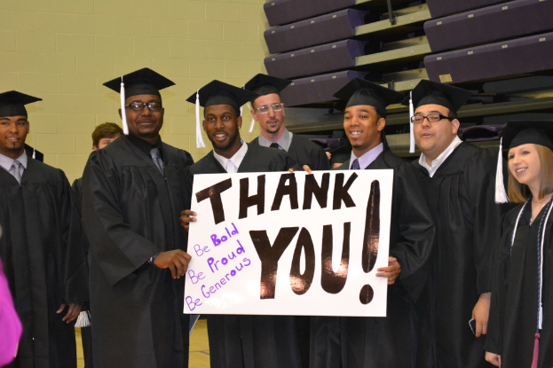 Eine Gruppe von Menschen, die in einer Reihe stehen und jeweils ein Plakat mit der Aufschrift 'danke' halten.