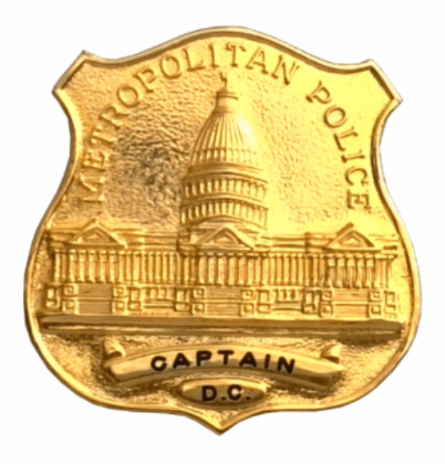 Ein goldenes Polizeidienstabzeichen mit der Inschrift "Metropolitan Police Captain" auf einem weißen Hintergrund.
