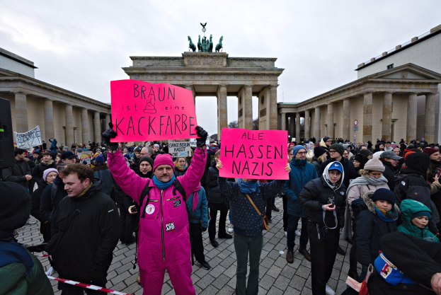 Gruppe von Menschen demonstriert vor dem Brandenburger Tor in Berlin, hält Schilder gegen die Anti-Nazis-Bewegung der deutschen Regierung.