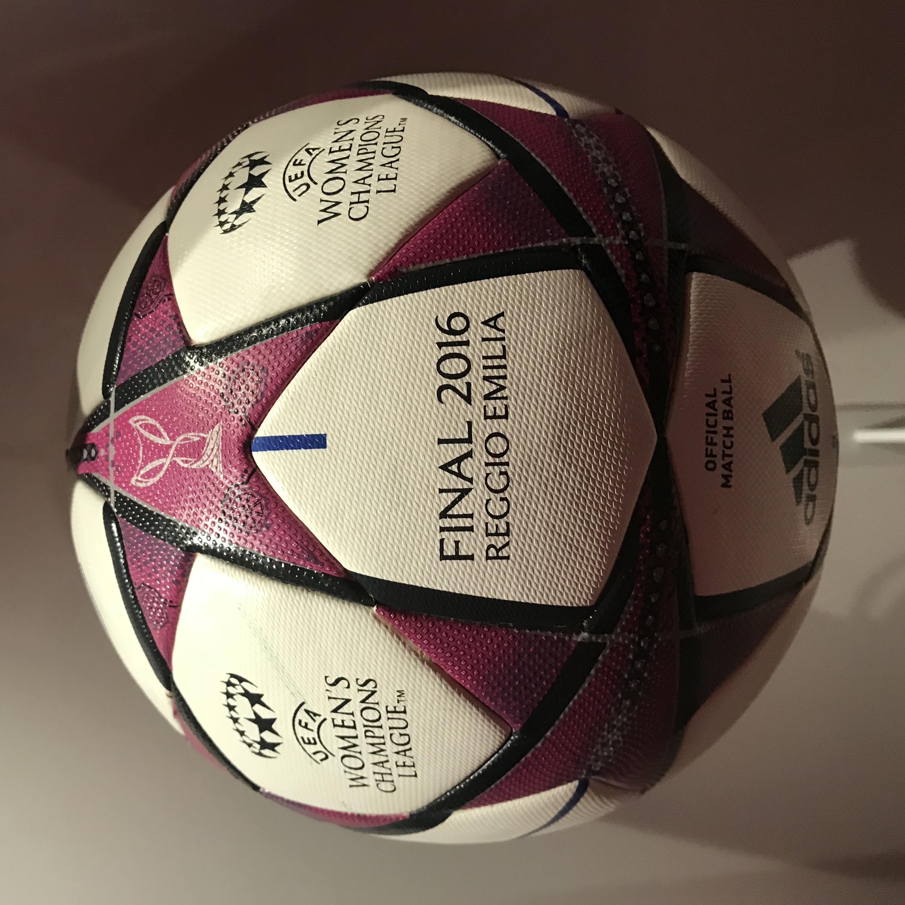 Ein Fußball auf einem weißen Tisch mit der Aufschrift "UEFA Women's Champions League Final 2016" in Weiß, Rosa und Schwarz.