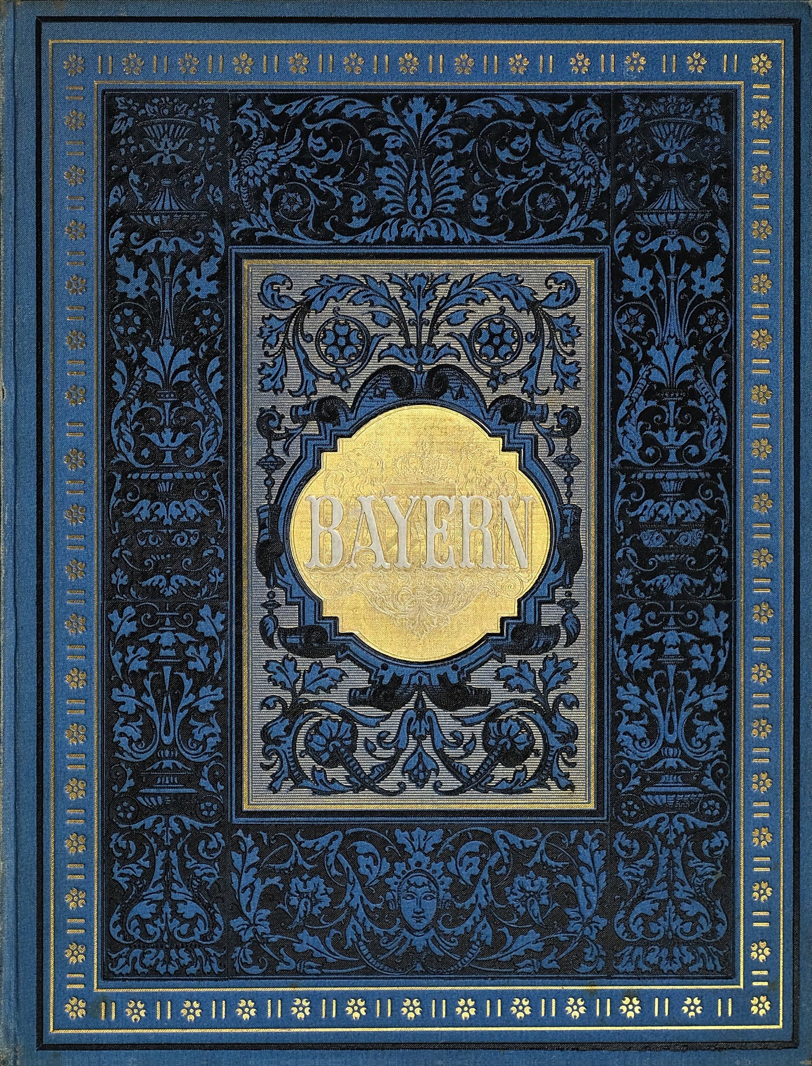 Ein blau-goldenes Buch mit der Aufschrift 'Bayern' auf dem Cover, das mit detaillierten Dekorationen verziert ist.