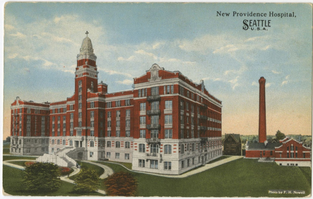 Postkartenansicht des New Providence Hospitals in Seattle, Washington, das ein großes Gebäude mit Fenstern, Treppen mit Geländern, Bäume, Gras und einen bewölkten Himmel zeigt.