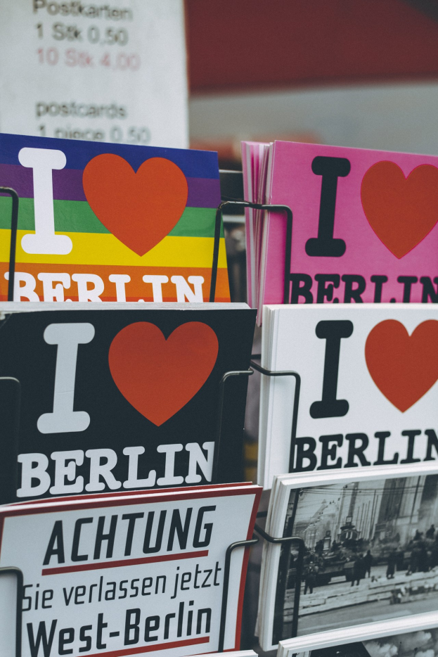Ein Gestell mit verschiedenen Büchern und Postern, auf denen "Ich liebe Berlin" geschrieben steht, mit einem unscharfen Hintergrund.