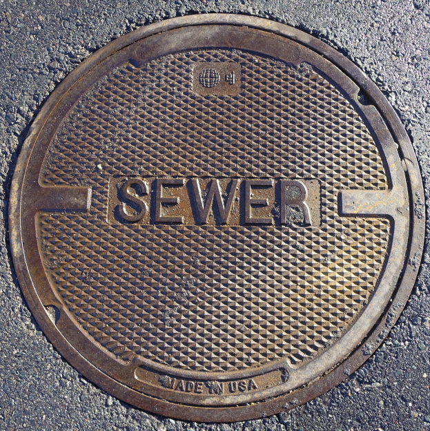 Metall-Schachtobjekt auf einer Straße mit der Aufschrift "Kanal"