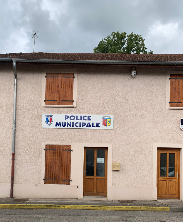 Gebäude der Polizei Wuppertal mit einem Schild, Fenstern, Türen, einer Namensplakette, einem Rohr, einem Baum und einem bewölkten Himmel im Hintergrund.
